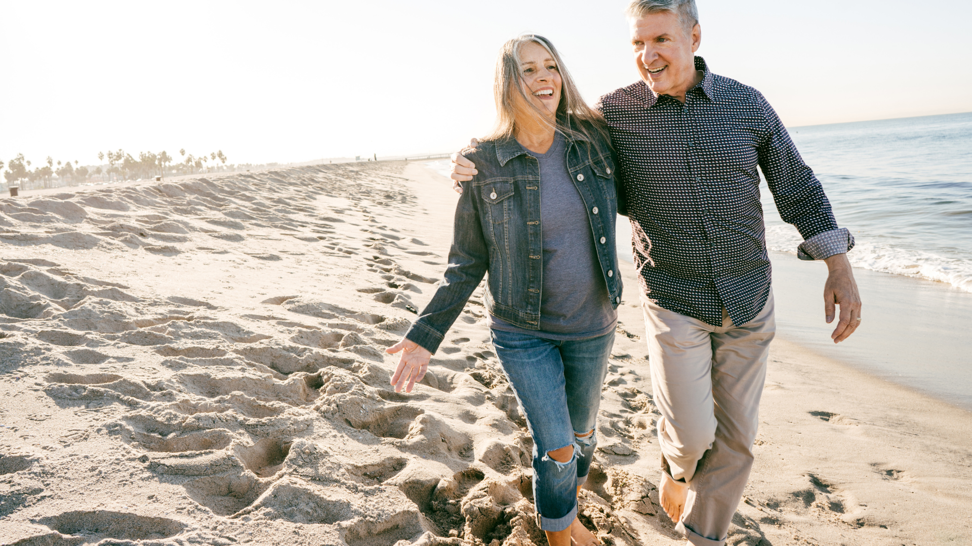 A couple walking together along a bright beach
