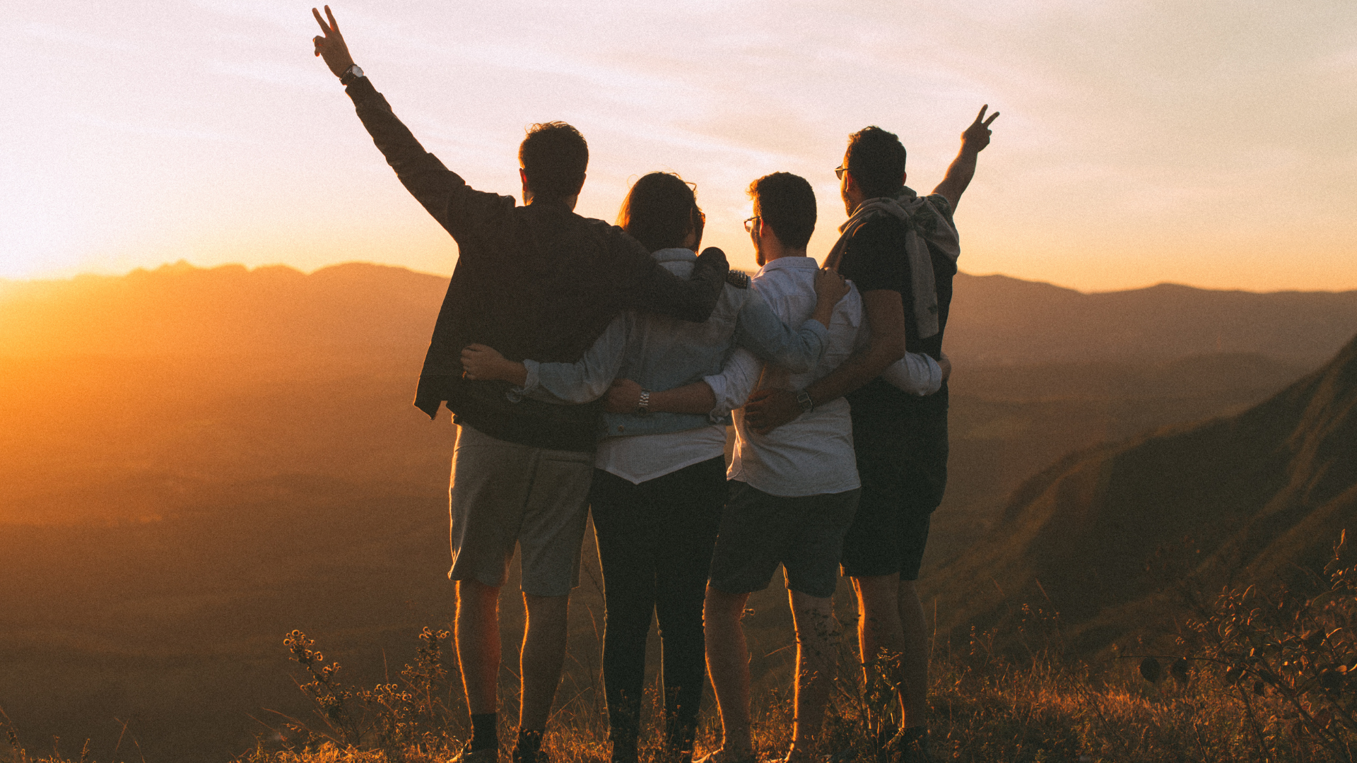 Social Fitness A group of friends stands together overlooking the mountains at sunset